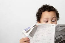 Kind liest Zeitungsartikel